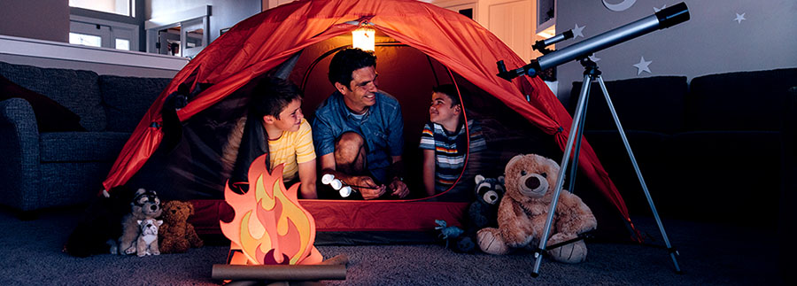 Father and sons camping indoors